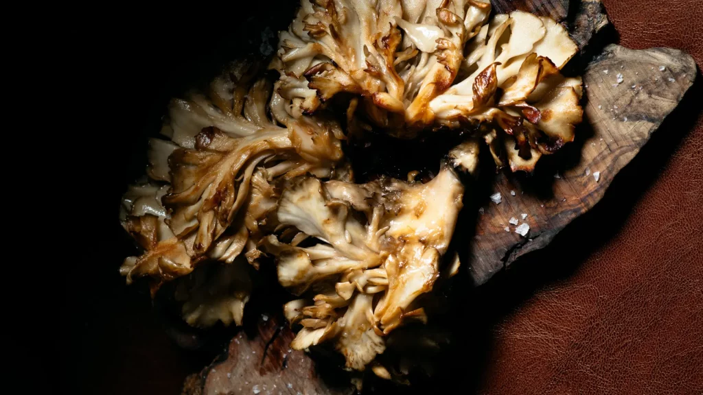 Setas shiitake a la brasa acompañando salmón en Carnal Steakhouse, restaurante de carne en el Eixample de Barcelona