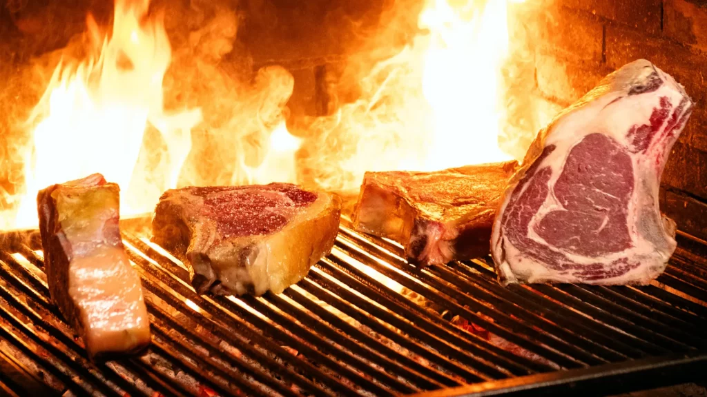 Brasa de leña con fuego vivo en la cocina de Carnal Steakhouse, restaurante de carne a la brasa en el Eixample de Barcelona